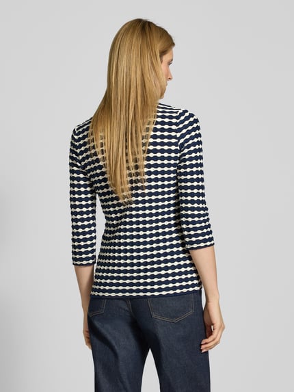 Vrouwenmodel draagt T-Shirt im Allover-Look met 3/4-mouw van Betty Barclay, slim fit, allover patroon, ronde hals, ruglengte 57 cm, totale achteraanzicht.