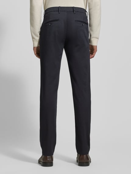 Männermodel trägt Slim Fit Chino aus Baumwoll-Mix Modell 'BLEECKER' von Tommy Hilfiger, Optik: Unifarben, Ganzkörperansicht Rückansicht.