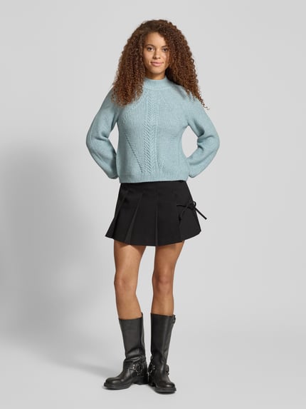 Kobiece model prezentuje Regular Fit Strickpullover aus Viskose-Mix Modell 'KATIA' od Only w kolorze jasnoniebieski melanż z wzorem warkocza, raglanowe rękawy, prążkowane wykończenia, widok całej sylwetki z przodu.
