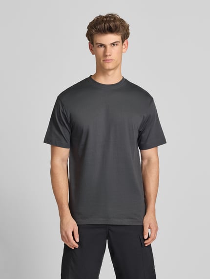 Männermodel trägt Relaxed Fit T-Shirt aus reiner Baumwolle Modell 'FRED LIFE' von Only & Sons, Optik: Unifarben, Ganzkörperansicht von vorne.