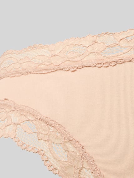 Frauenmodel trägt Slim Fit Slip mit Spitzenbesatz Modell 'Rio' von Skiny, pastellfarben, Micromodal-Mix, Detailaufnahme.