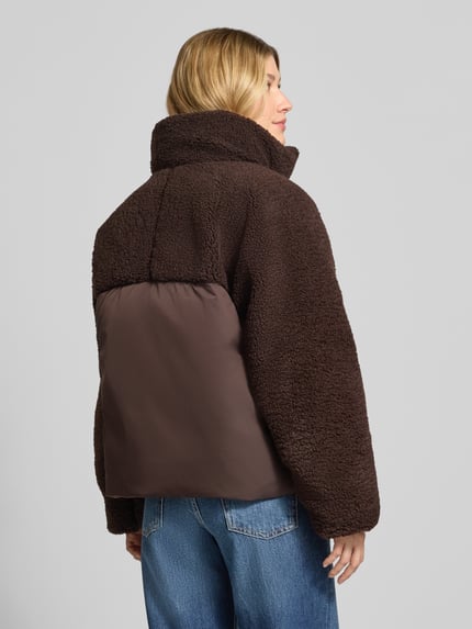 Frauenmodel trägt Steppjacke Modell 'Hazy' mit Fleece-Einsätzen von OPUS, unifarben in Dunkelbraun, lange Ärmel, Webware, Ganzkörperansicht Rückansicht.