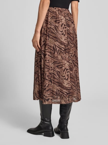 Frauenmodel trägt Glockenrock mit elastischem Bund Modell 'Se44renity' von ZABAIONE, braunes Material mit dunklem Tigerprint, Midirock, A-Linie, Material-Mix mit Stretch-Anteil, Ganzkörperansicht Rückansicht.