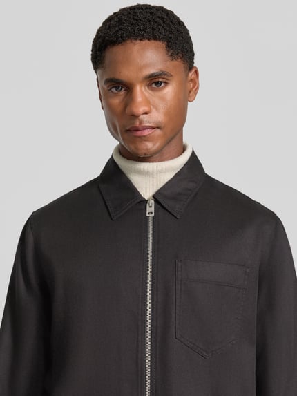 Männermodel trägt Regular Fit Bomberjacke / Blouson aus Lyocell-Baumwoll-Mix Modell 'Enasoz' von HUGO in Schwarz, Nahaufnahme Oberkörper. Herren Bomberjacke / Blouson von HUGO.