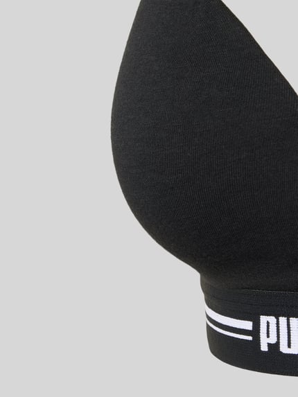 Frauenmodel trägt Bralette mit Logo-Bund von PUMA aus Baumwollmischung mit Modal- und Stretch-Anteil, Nahaufnahme Oberkörper.