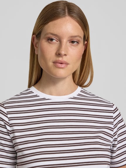 Vrouwenmodel draagt T-shirt met ronde hals model 'NORA' van VILA, mix van katoen en elastaan, regular fit, ruglengte maat S 57 cm, nahaufnahme bovenlichaam.