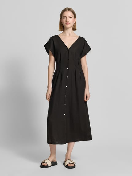 Frauenmodel trägt Midikleid aus Leinen-Viskose-Mix mit V-Ausschnitt von ICHI, taillierter Schnitt, schwarze Farbe, Ganzkörperansicht von vorne.