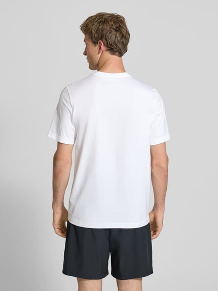 Męski model nosi T-Shirt mit Logo-Print Modell 'Swoosh' von Nike, biała bawełna, prosty krój, okrągły dekolt, długość tyłu 73 cm, Ganzkörperansicht Rückansicht.