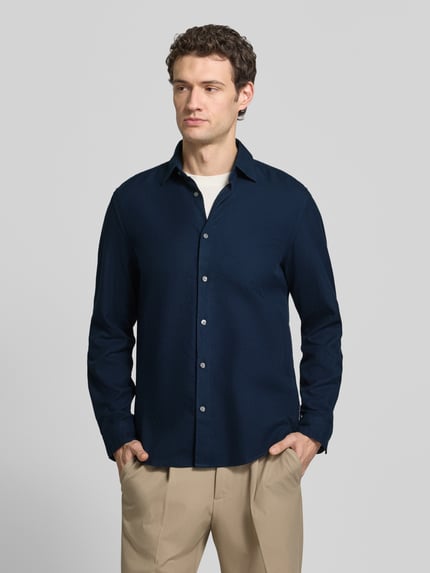 Männermodel trägt Regular Fit Freizeithemd mit Strukturoptik von MARC O'POLO in Unifarbe, Knopfleiste, Ganzkörperansicht von vorne.