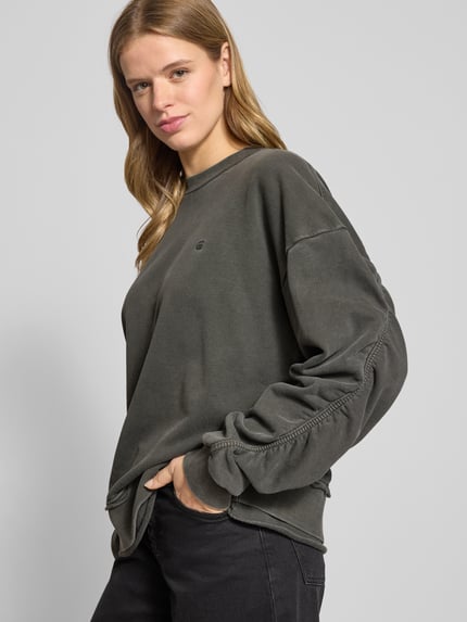 Frauenmodel trägt Oversized Sweatshirt mit gerippten Abschlüssen von G-Star aus reiner Baumwolle, Rundhalsausschnitt, Label-Stitching, Nahaufnahme Oberkörper.