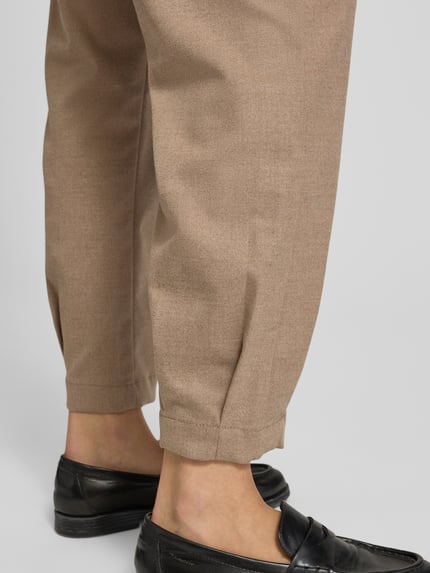 Frauenmodel trägt Weite Hose mit elastischem Bund von OPUS in Beige, unifarben, Bundfalte, Gummizug, aufgesetzte Seitentasche, Nahaufnahme Beine.
