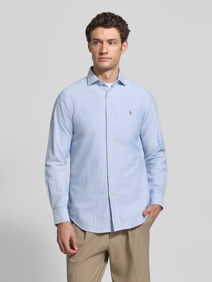 Männermodel trägt Regular Fit Freizeithemd aus reiner Baumwolle von Polo Ralph Lauren, hellblau-weiß gestreift, Ganzkörperansicht von vorne. Herren Freizeithemd von Polo Ralph Lauren