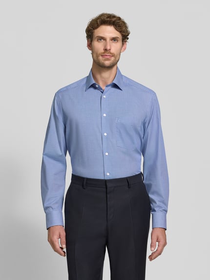 Männermodel trägt Comfort Fit Businesshemd aus reiner Baumwolle von OLYMP in Hellblau, glatte Struktur, Ganzkörperansicht von vorne, Herren Businesshemd von OLYMP Luxor.