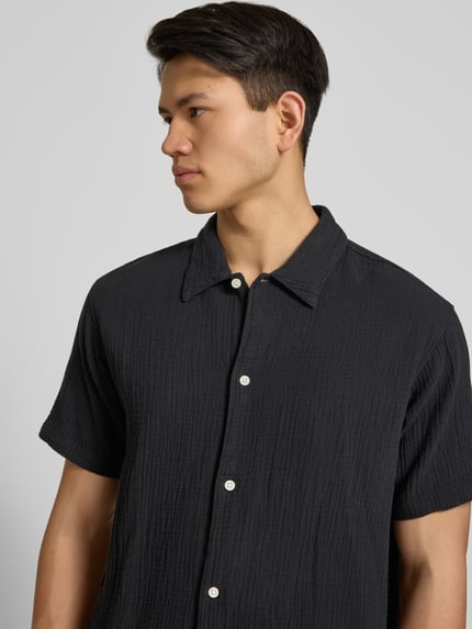 Männermodel trägt Regular Fit Freizeithemd mit Kentkragen von Jack & JonesR in Schwarz, reine Baumwolle, Nahaufnahme Oberkörper.