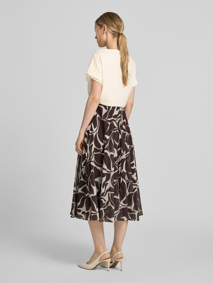 Frauenmodel trägt Cocktailkleid im 2-in-1-Look mit Drapierungen von Christian Berg Cocktail, A-Linie, Midikleid, gemustert, Rückenlänge 116 cm, Brustweite 45 cm, Ganzkörperansicht Rückansicht.