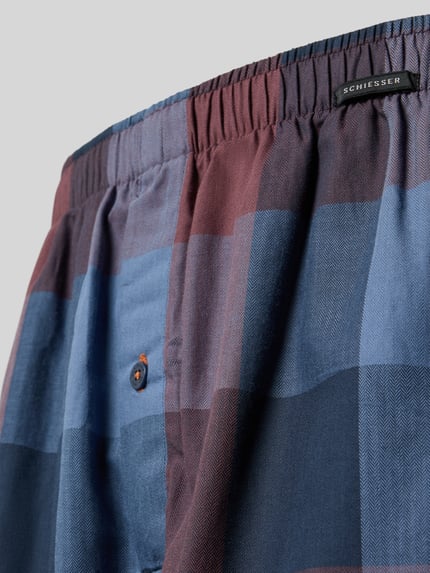 Produktfoto, Regular Fit Boxershorts aus reiner Baumwolle im 2er-Pack von SCHIESSER, kariertes Muster in Blau- und Brauntönen, elastischer Bund, Label-Detail, angenehme Baumwolltextur, Nahaufnahme.
