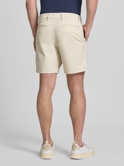 Männermodel trägt Shorts mit französischen Eingrifftaschen von GAP in Beige, Baumwoll-Mix mit Stretch-Anteil, Ganzkörperansicht Rückansicht.