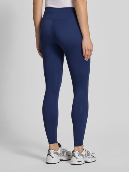 Frauenmodel trägt Leggings mit Logo-Print Modell 'One' von NIKE TRAINING aus Material-Mix mit Stretch-Anteil, Slim-Fit, elastischer Bund, Ganzkörperansicht Rückansicht.