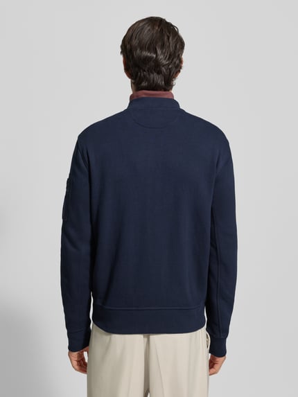Männermodel draagt Sweatjacke met geribde boorden van Polo Ralph Lauren, regular fit, opstaande kraag, ruglengte maat M 57 cm, mouwlengte 70 cm, labelstitching, drukknoopzakken. Ganzkörperansicht Rückansicht.