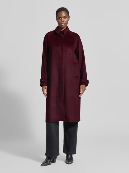 Frauenmodel trägt Regular Fit Mantel mit Stehkragen von Christian Berg Woman Selection in Dunkelrot, glatte Textur, Eingrifftaschen, Knopfverschluss, Ganzkörperansicht von vorne. Rückenlänge 111 cm, Schulterbreite 38 cm, Brustweite 35 cm, Ärmellänge 46 cm.