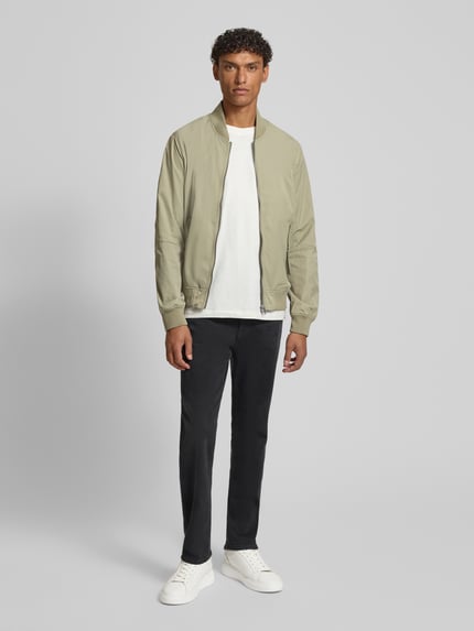 Männermodel trägt Regular Fit Bomberjacke mit Stehkragen von s.Oliver RED LABEL, uni, langarm, gerippte boorden, zijzakken, vooraanzicht ganzkörper