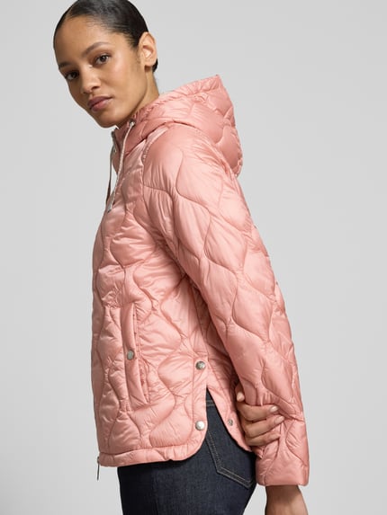 Frauenmodel trägt Steppjacke mit Kapuze und Zweiwege-Reißverschluss von Fuchs Schmitt in Rosa mit Eingrifftaschen, Regular Fit, Rückenlänge 62 cm, Schulterbreite 42 cm, Brustweite 53 cm, Ärmellänge 61 cm, Nahaufnahme Oberkörper.