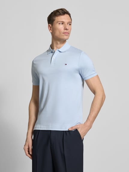 Mannelijk model draagt Regular Fit Poloshirt uit puur katoen Model 'LIQUID COTTON' van Tommy Hilfiger, melangelook, gestikt logo, polokraag, korte mouw, mouwboord geribd, rompzoom met zijsplitten, materiaal puur katoen, frontale opname van het bovenlichaam.