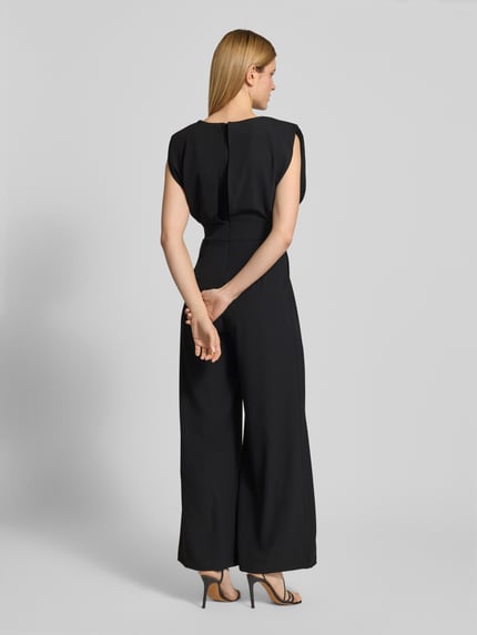 Modelka nosi Regular Fit Jumpsuit mit Rundhalsausschnitt od Rinascimento, czarny, materiał elastyczny, brak rękawów, krój regular fit, taliowany, kellerfalten, zdjęcie całej sylwetki z tyłu.