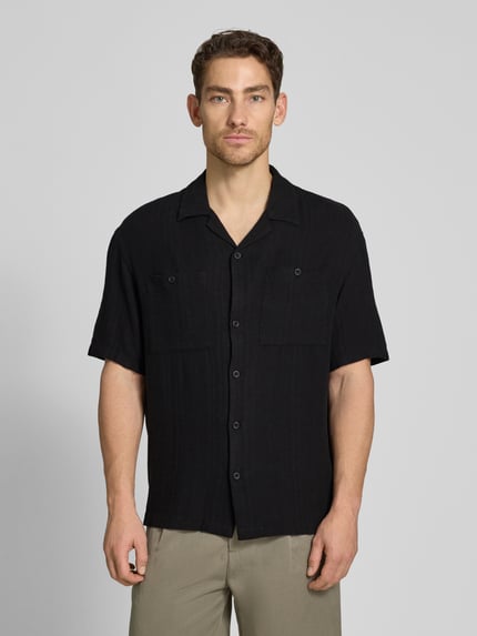 Männermodel trägt Loose Fit Freizeithemd aus Leinen-Viskose-Mix von Tom Tailor Denim, Optik: Unifarben, Kurzarm, Ganzkörperansicht von vorne.