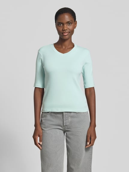 Frauenmodel trägt T-Shirt mit Rundhalsausschnitt von Christian Berg Woman aus Baumwoll-Elasthan-Mix, Slim-Fit, 1/2-Arm, Farbe Hellblau, Rückenlänge bei Größe S 53 cm, Ganzkörperansicht von vorne.