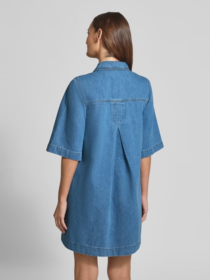Modelka kobieca ma na sobie Jeanskleid mit Brusttaschen Modell 'Mira' od mbyM, bawełna, krój relaxed fit, sukienka mini, kołnierzyk koszulowy, kieszenie na piersi, listwa guzikowa, długość tyłu w rozmiarze S: 89 cm, szerokość w rozmiarze S: 43 cm, długość rękawów w rozmiarze S: 34 cm, niebieski denim, całkowity widok z tyłu.