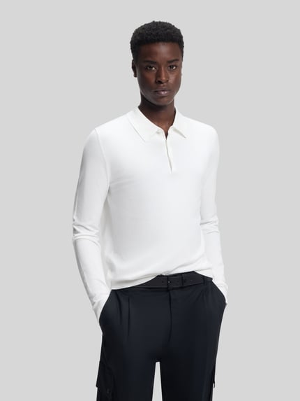 Męski model nosi Slim Fit Strick-Poloshirt aus Viskose-Mix Modell 'SAN PIPPO-CV' od HUGO, biała dzianina, krój slim fit, całkowity widok od przodu.