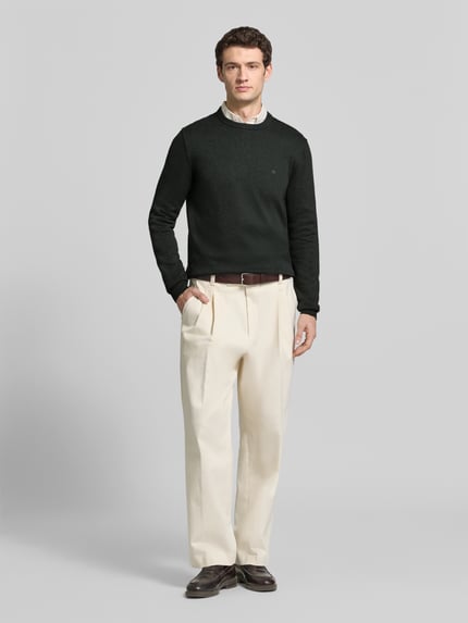 Mannelijk model draagt Regular Fit gebreide pullover uit mix van katoen en wol van Christian Berg Men, donker met labelstitching, ronde hals, heren, ruglengte maat M 70 cm, mouwlengte maat M 68 cm, full body vooraanzicht.