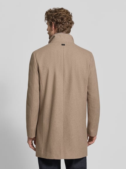 Männermodel trägt Mantel mit Stehkragen Modell 'FINLAN' von STRELLSON, unifarben beige, strukturierte Webware, Ganzkörperansicht Rückansicht.