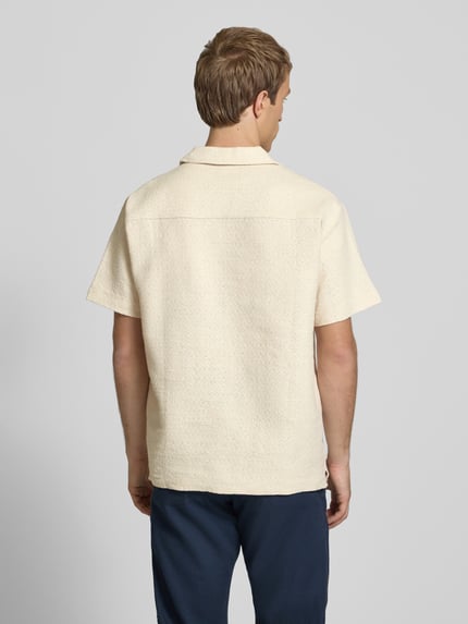 Männermodel trägt Regular Fit Poloshirt mit V-Ausschnitt von Jack & Jones in Beige, reine Baumwolle, Strickstruktur, Ganzkörperansicht Rückansicht.