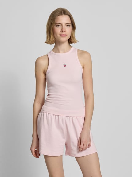 Frauenmodel trägt Tanktop mit Rundhalsausschnitt von REVIEW in zartem Rosa, Baumwoll-Elasthan-Mix, Feinripp, eng anliegende Passform, Ganzkörperansicht von vorne.