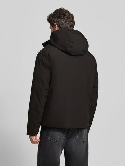 Männermodel trägt Jacke mit Kapuze und Pattentaschen Modell 'LAMOON' von JACK & JONES in Schwarz, Regular Fit, Ganzkörperansicht Rückansicht. Rückenlänge 72 cm, Schulterbreite 50 cm, Brustweite 60 cm, Ärmellänge 65 cm.