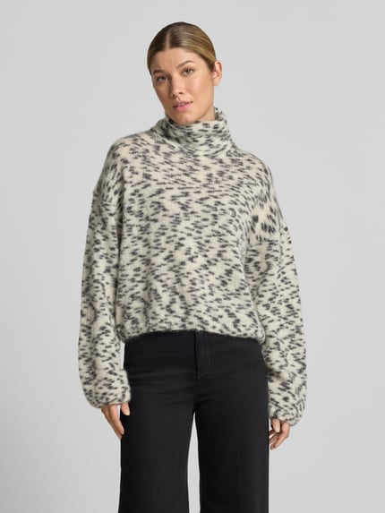 Frauenmodel trägt Oversized Turtleneck-Pullover aus Woll-Mix von ARMEDANGELS in Creme mit grauem Muster, weiche Textur, Ganzkörperansicht von vorne. Damen Turtleneck-Pullover von ARMEDANGELS.
