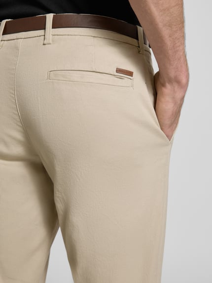 Männermodel trägt Slim Fit Stoffhose mit abnehmbarem Gürtel Modell 'Marco' von JACK & JONES, Beige, Baumwoll-Mix, Detailaufnahme Rückansicht, Gesäßtasche sichtbar, Bundweite und Innenbeinlänge gemäß Kontext.