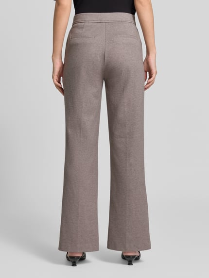 Frauenmodel trägt Boocut Fit Stoffhose mit Viskose-Anteil von Christian Berg Woman in Beige, Ziernähte und Paspeltaschen, Ganzkörperansicht Rückansicht.