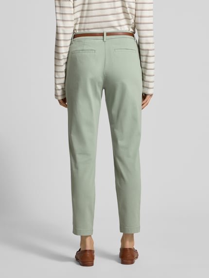 Frauenmodel trägt Stoffhose mit Eingrifftaschen von comma in hellem Grün, Baumwoll-Mix mit Stretch, gerader Schnitt, Ganzkörperansicht Rückansicht.