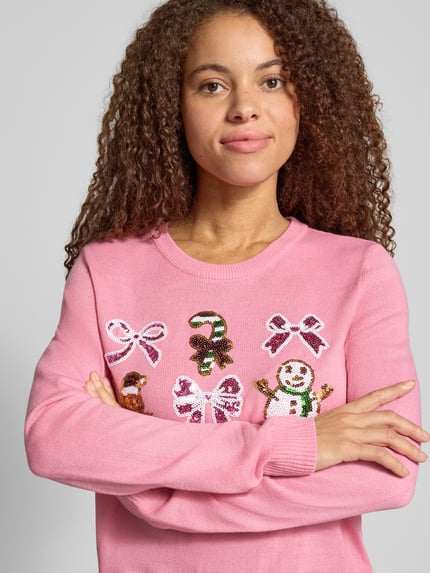 Frauenmodel trägt Rollkragenpullover mit weihnachtlichem Motiv-Print von ONLY, mehrfarbig, Strickoptik, Nahaufnahme Oberkörper.