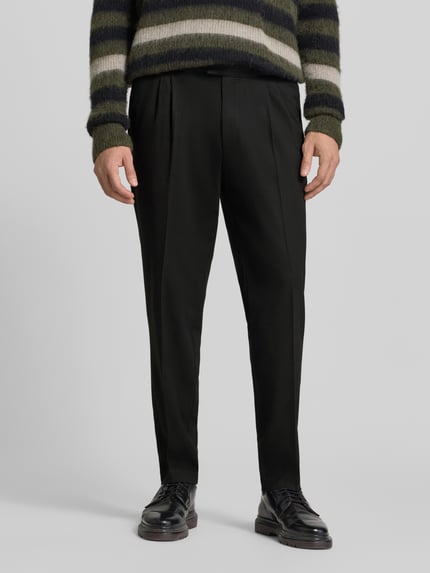 Männermodel trägt Regular Fit Bundfaltenhose mit Seitenriegel von MCNEAL, schwarze Farbe, glatte Textur, Nahaufnahme Oberkörper. Herren Bundfaltenhose, 1er-Bundfalte, Eingrifftaschen, Gesäßtaschen, Bundweite 45 cm, Innenbeinlänge 78 cm.
