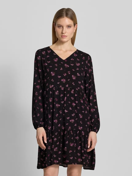 Vrouwenmodel draagt Minikleid aus Viskose mit V-Ausschnitt van Zero, zwart met roze print, getailleerd model, V-hals, elastische mouwboorden, ruglengte maat 36: 80 cm, borstwijdte: 39 cm, mouwlengte: 60 cm, zuiver viscose. Ganzkörperaanzicht van voren.