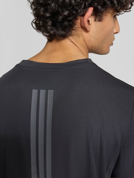 Männermodel trägt Regular Fit Sport T-Shirt mit Label-Print von adidas Training, Optik: Unifarben, Materialverarbeitung: Stretch-Webstruktur, Ganzkörperansicht Rückansicht.