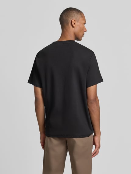 Männermodel trägt zwart regular fit t-shirt van katoenmix model 'SPENCER' van Selected, Heren t-shirt, Ganzkörperansicht Rückansicht.