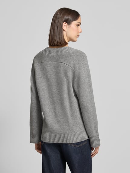 Frauenmodel trägt Pullover aus Wolle mit Logo-Detail von Tommy Hilfiger in grauer Melange mit Strukturmuster, Ganzkörperansicht Rückansicht.