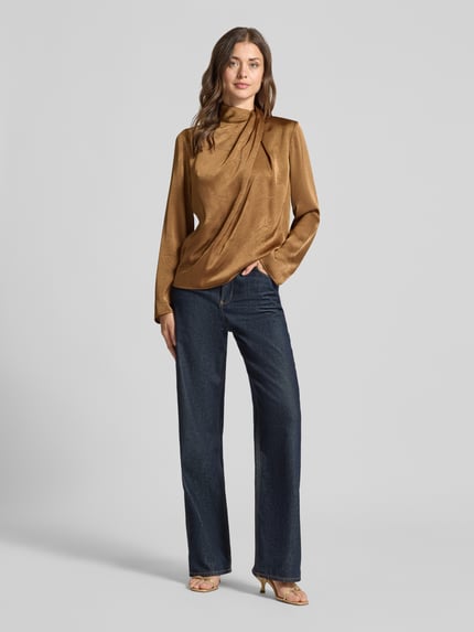 Vrouwenmodel draagt Regular Fit Langarmbluse aus Satin van Jake*s Collection in goudbruin, glanzende textuur, donkere jeans; volledige lichaamsaanzicht van voren.