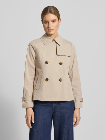 Vrouwenmodel draagt Trenchcoat mit Knopfverschluss van MICHAEL Michael Kors in beige, regular fit, platte kraag, met dubbele rij knopen, ruglengte maat S 61 cm, schouderbreedte 40 cm, borstwijdte 52 cm, mouwlengte 63 cm, Ganzkörperaanzicht van voren.