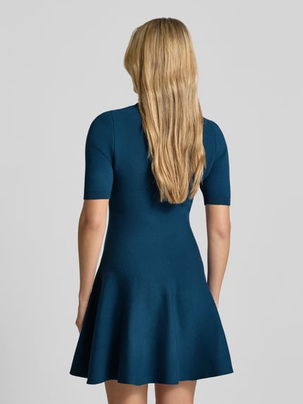Frauenmodel trägt Minikleid aus Viskose-Mix mit Stehkragen von Apricot in A-Linie, Farbe Blau, 1/2-Arm, Ganzkörperansicht Rückansicht.